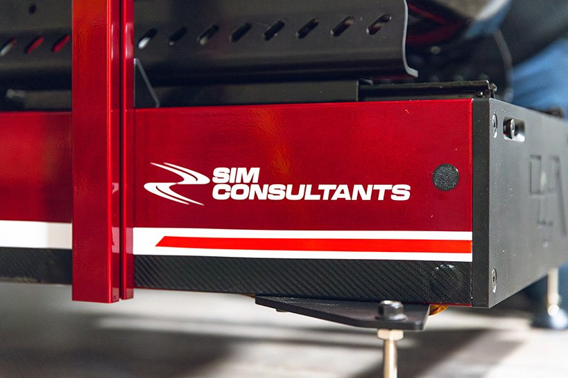 Close-up of a machine with the logo and name 'Sim Consultants' on a red panel.