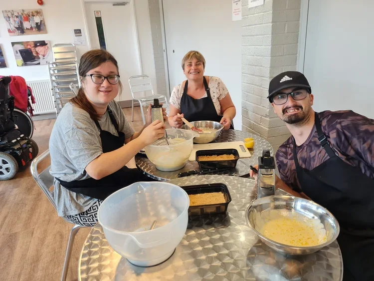 Three people sitting around a table cooking together