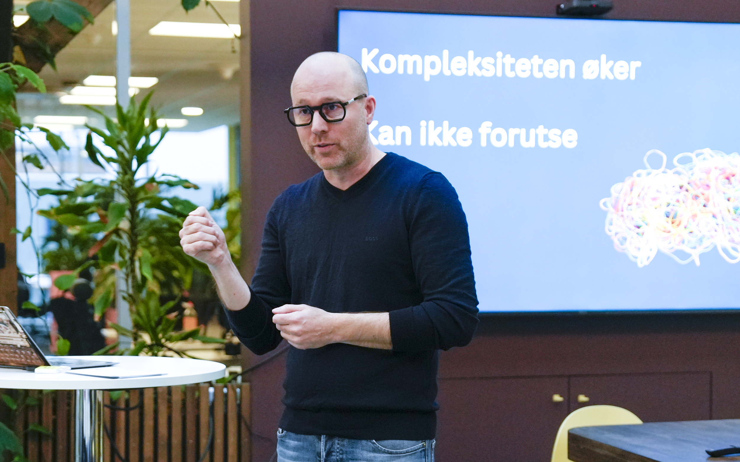 Kursholder John Inge Hervik står og prater foran en vegg der det står "kompleksiteten øker. Kan ikke forutse". Foto