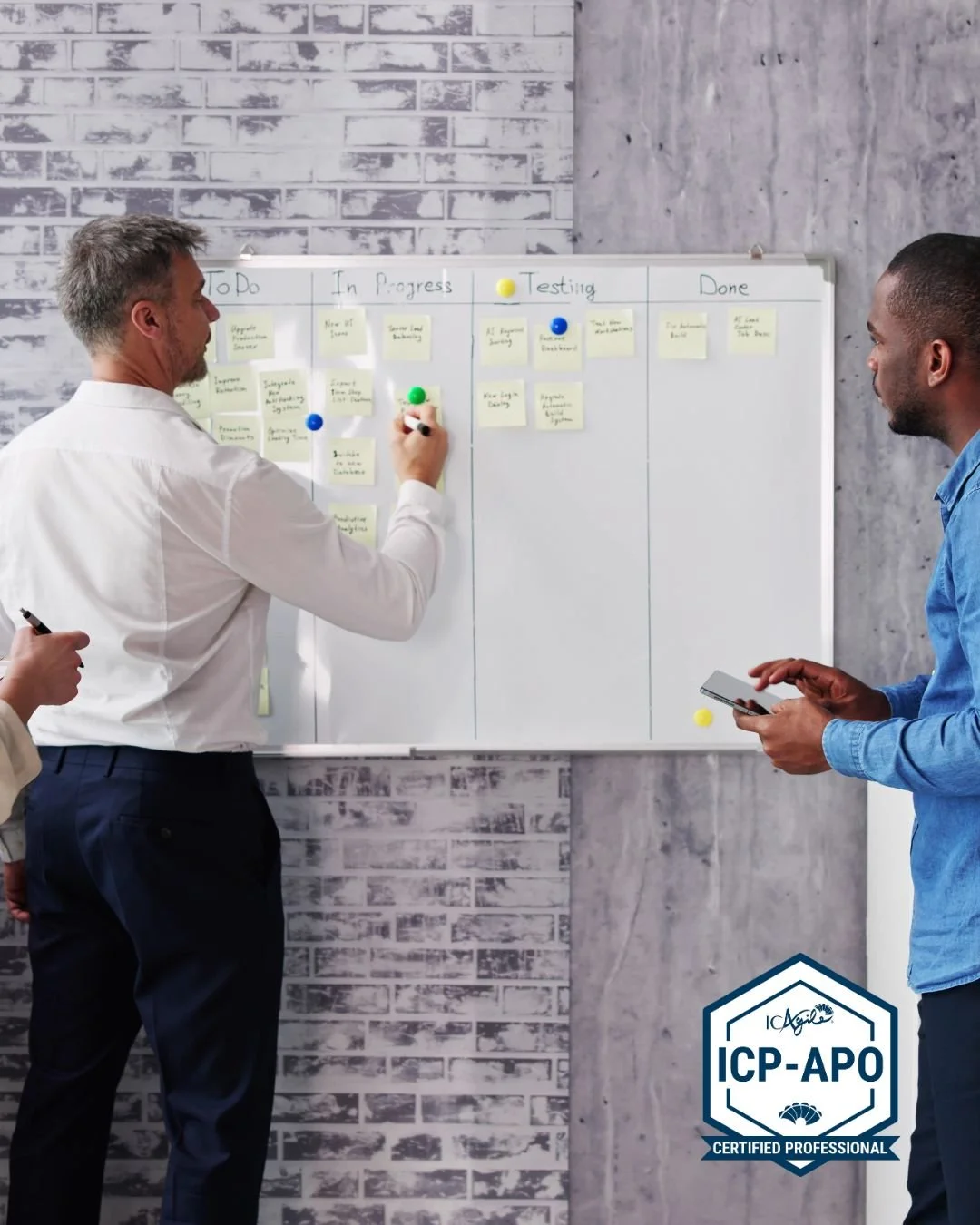 Bilde av to menn som står foran en tavle og noterer på post-its. Foto