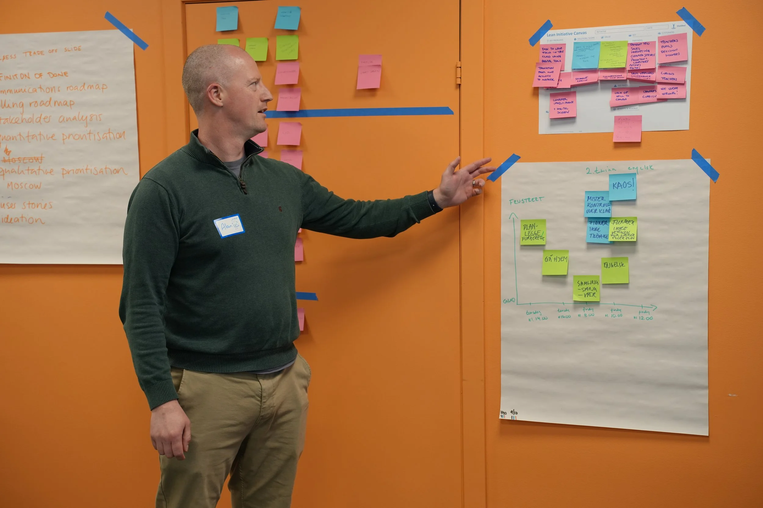 Kursholder Alan Jennings forklarer mens han peker på en flipchart som henger på veggen. Foto