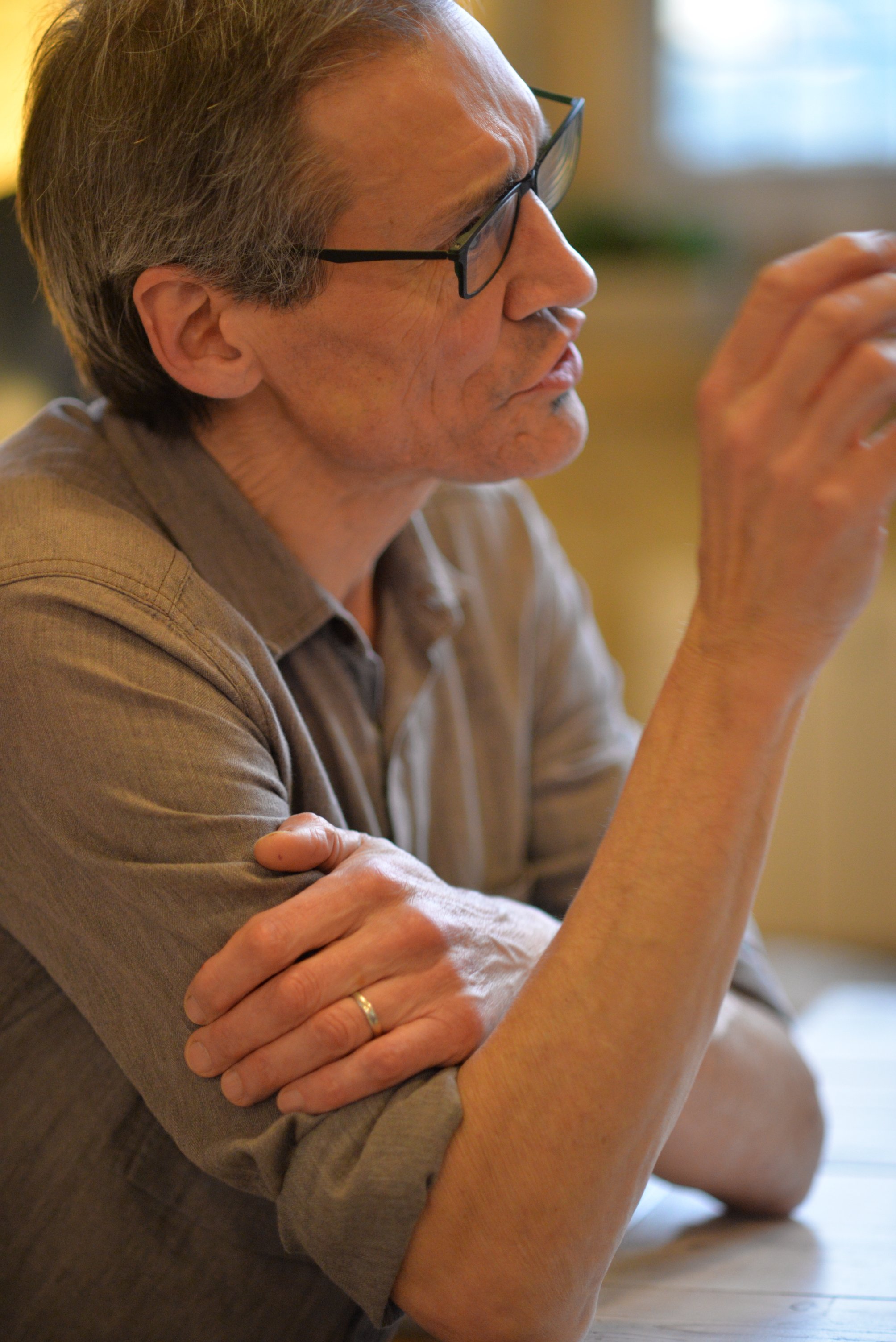 Kursholder Tobias Mayer sitter ved et bord og forklarer noe til kursdeltakere. Foto