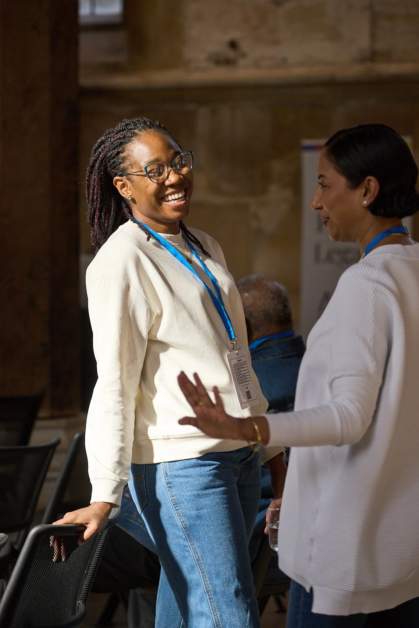 Two women chatting at a LawtechUK event at the Guildhall in York. One is lit up from the light through the windows, the other is in shade.