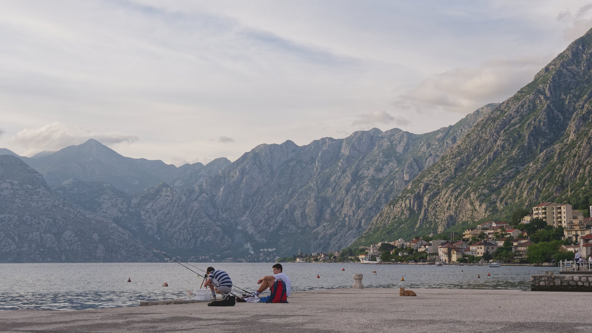 Two boys fishing in Boka Bay in the early evening.