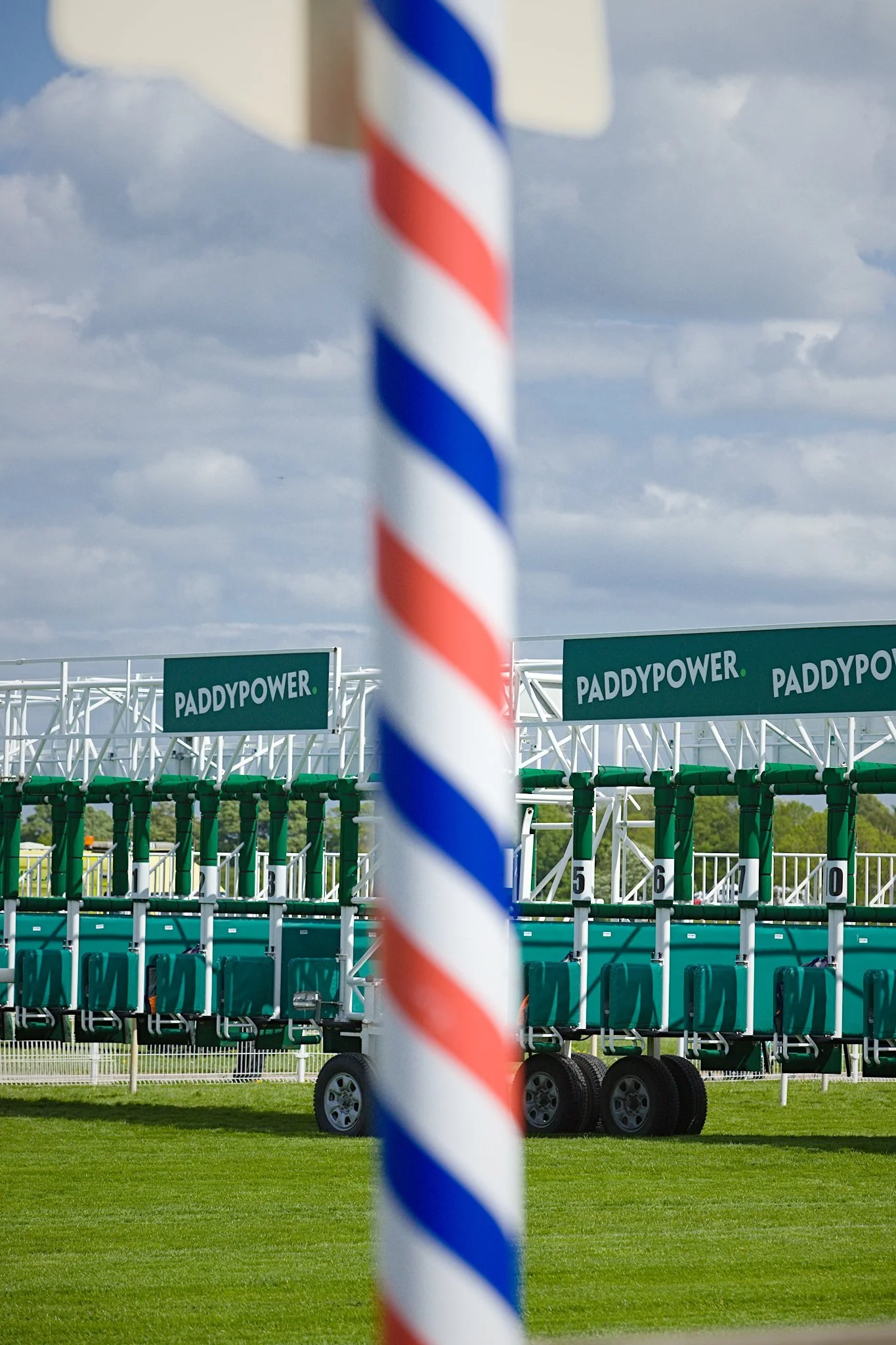 The starting gates of York Racecourse with Paddypower hoarding in front of an out of focus stripy pole of a furlong marker.