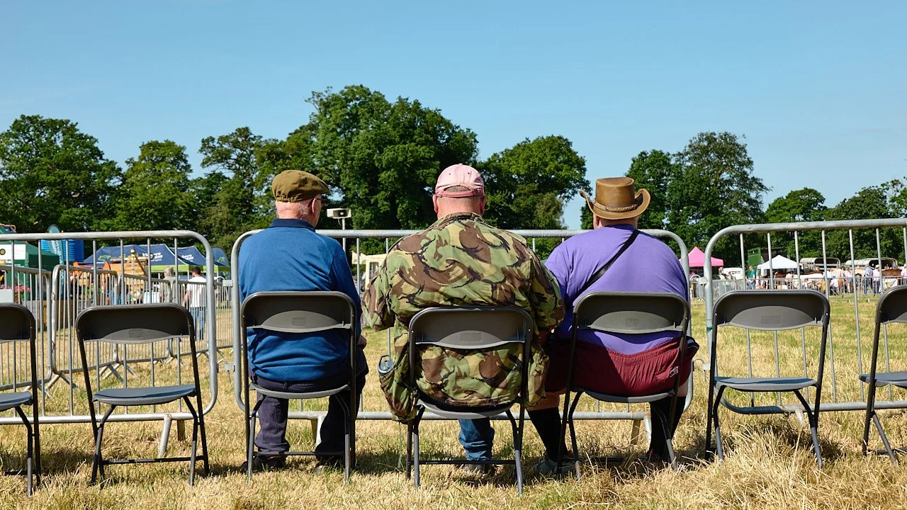 Three men waiting for the show to start in the main ring.