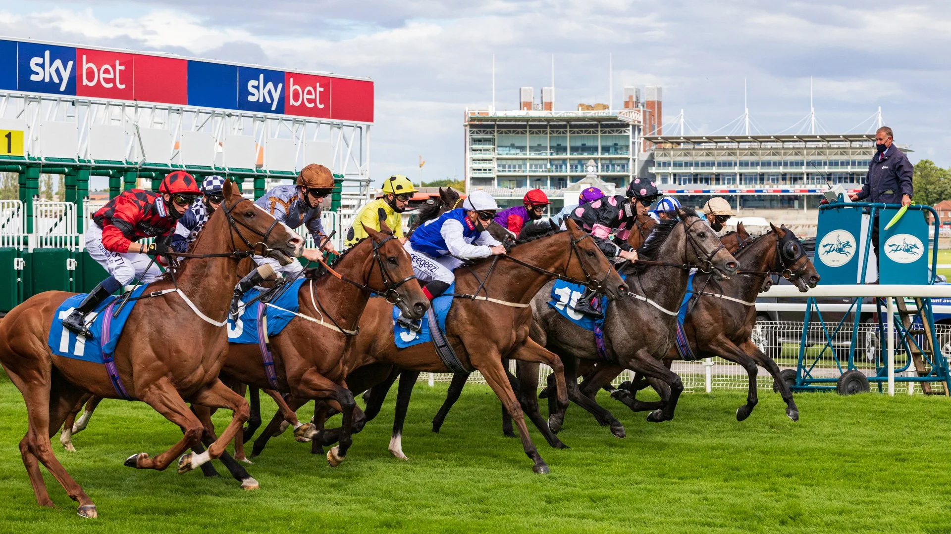 Jockeys and their horses leaving the starting gates at York Races during quiet racing in 2020.