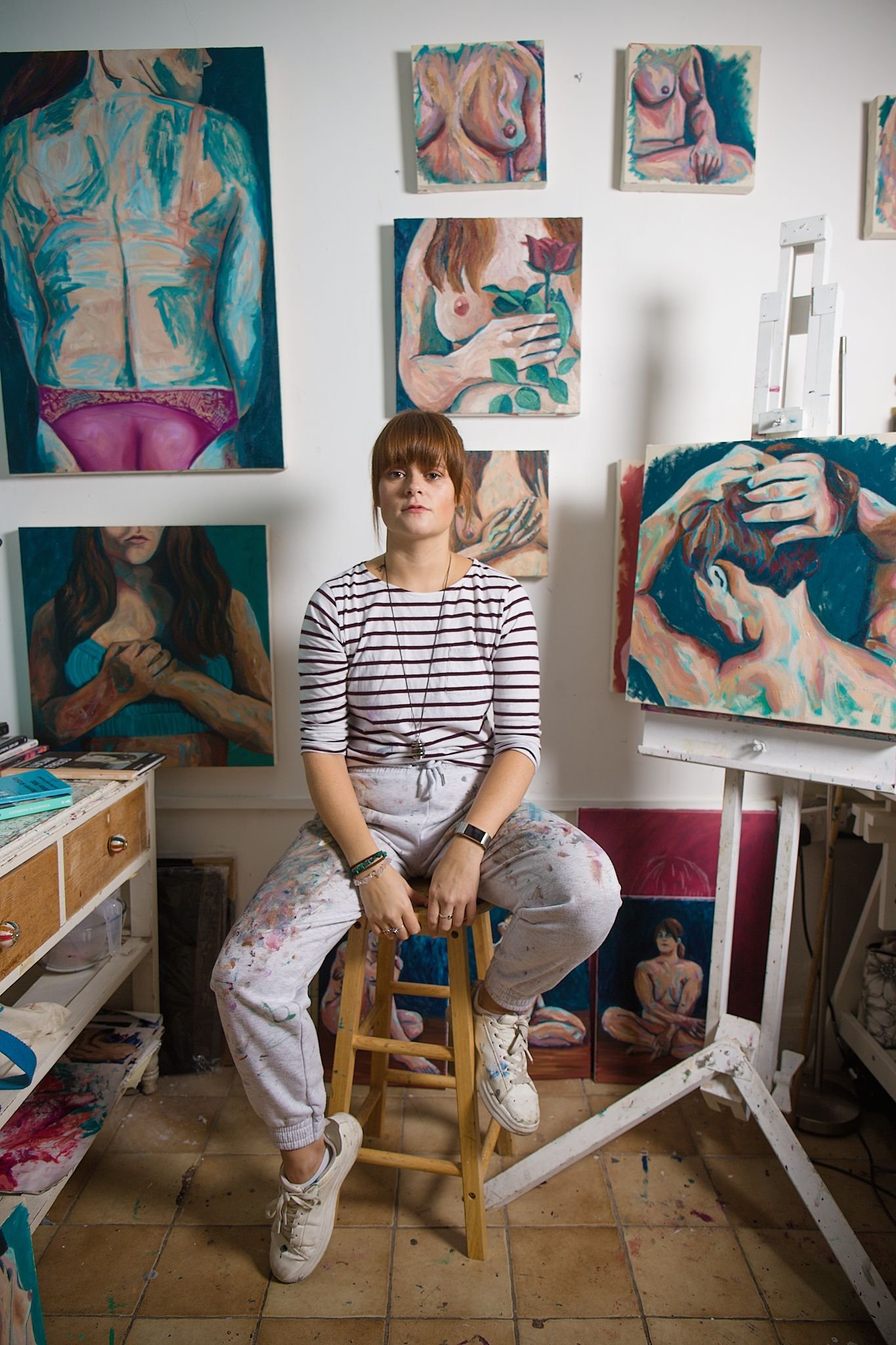 Artist Rae George sitting at her easel in her studio in York.