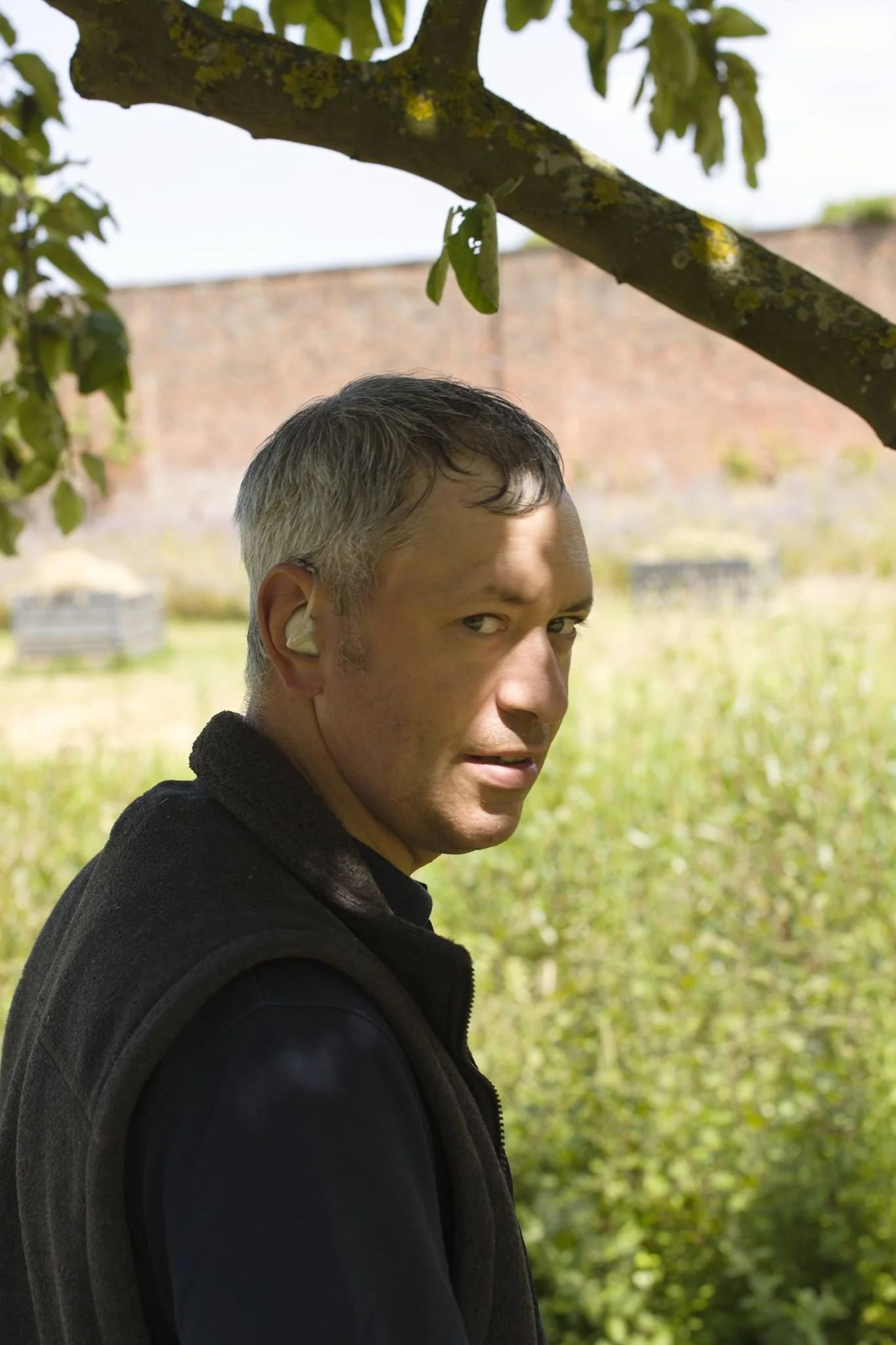 Portrait of a man looking over his in the shade of a tree during a hot day at the Archbishop's walled garden.