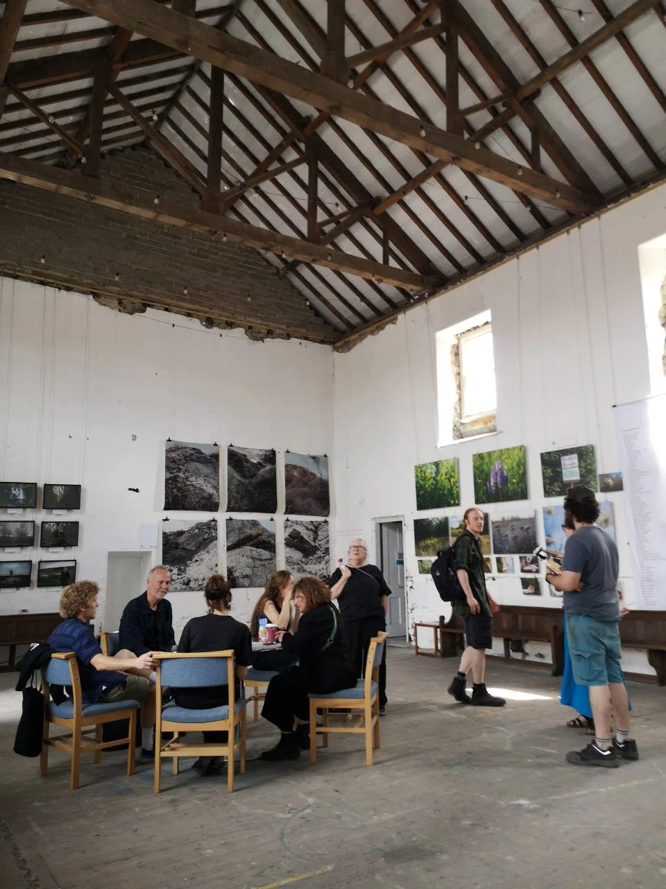 Groups of people sitting or standing in the Parish Project exhibition room at the Ryedale Film and Photo Fest in Malton.
