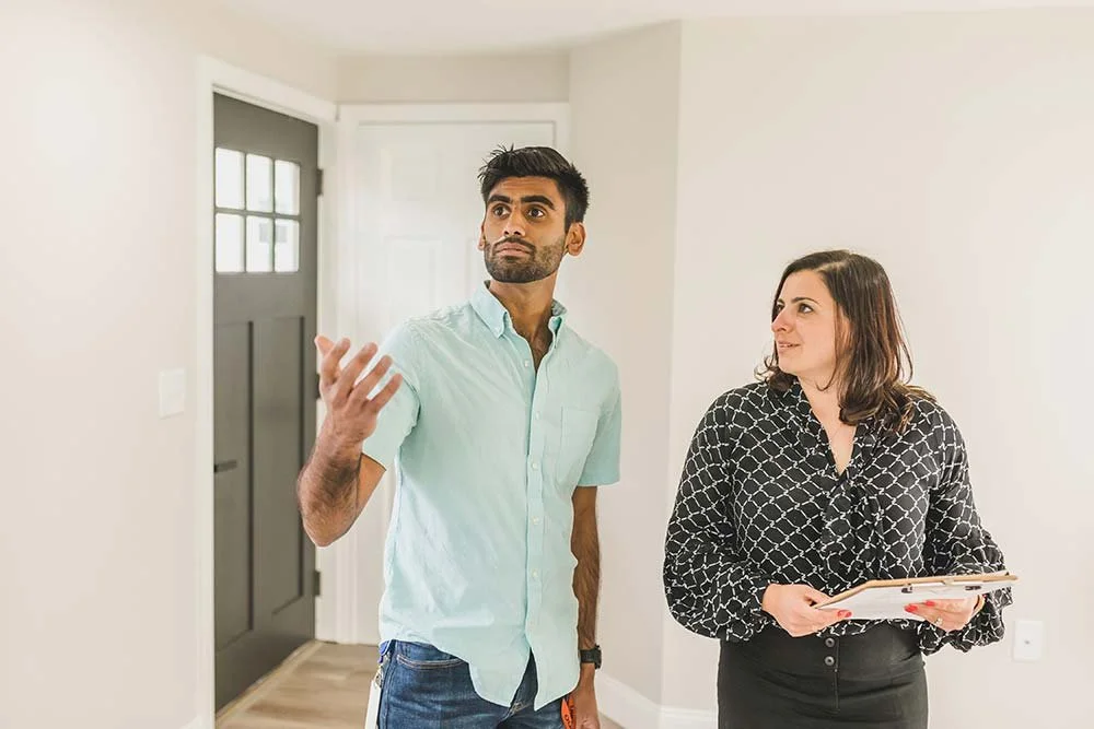 Man showing woman around his home.