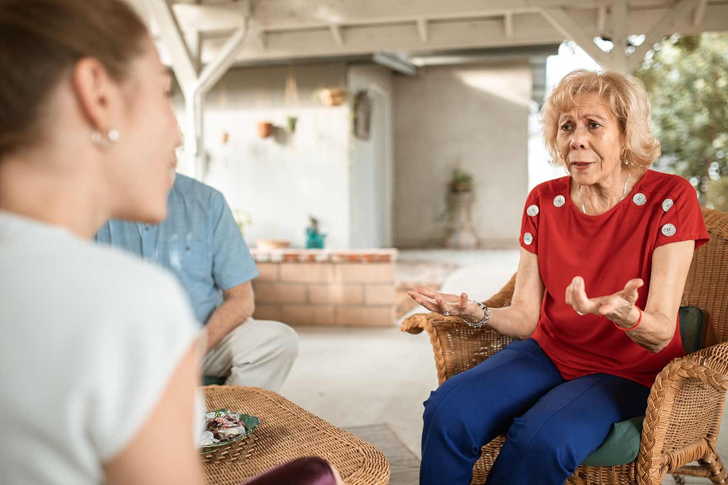 A Florida homeowner discussing a cash offer for her house with a local buyer on the porch.