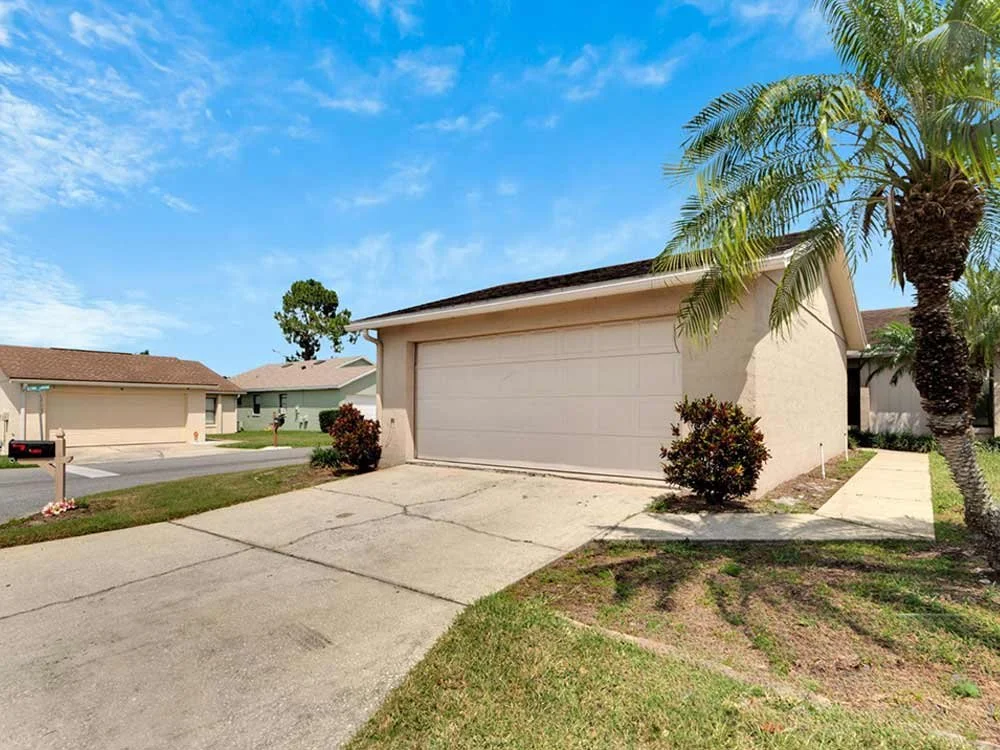 White ranch-style home with palm trees