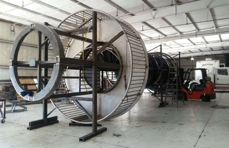 Large cylindrical metal structure being assembled in the UFB shop