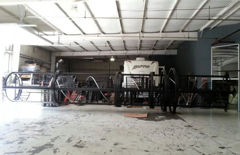 Custom black metal propeller fabrication inside an industrial shop
