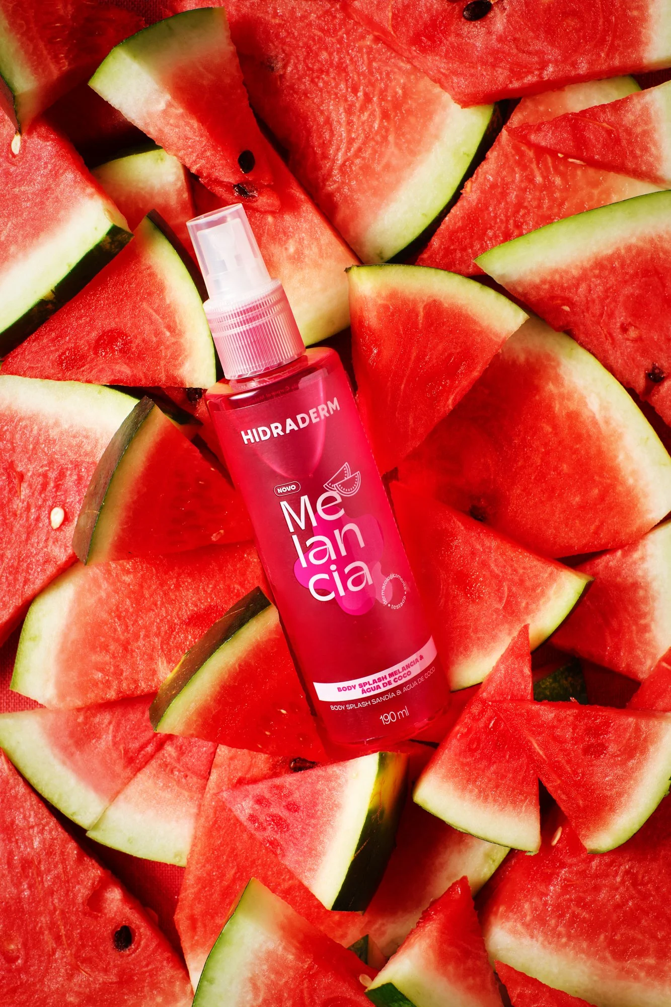 Um borrifador de hidratação sobre pedaços de melancia vermelha com casca verde.