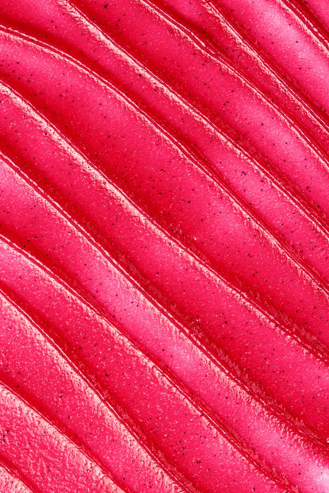 Close-up de uma fruta rosa, possivelmente pitaya, com superfície lisa e linhas diagonais.