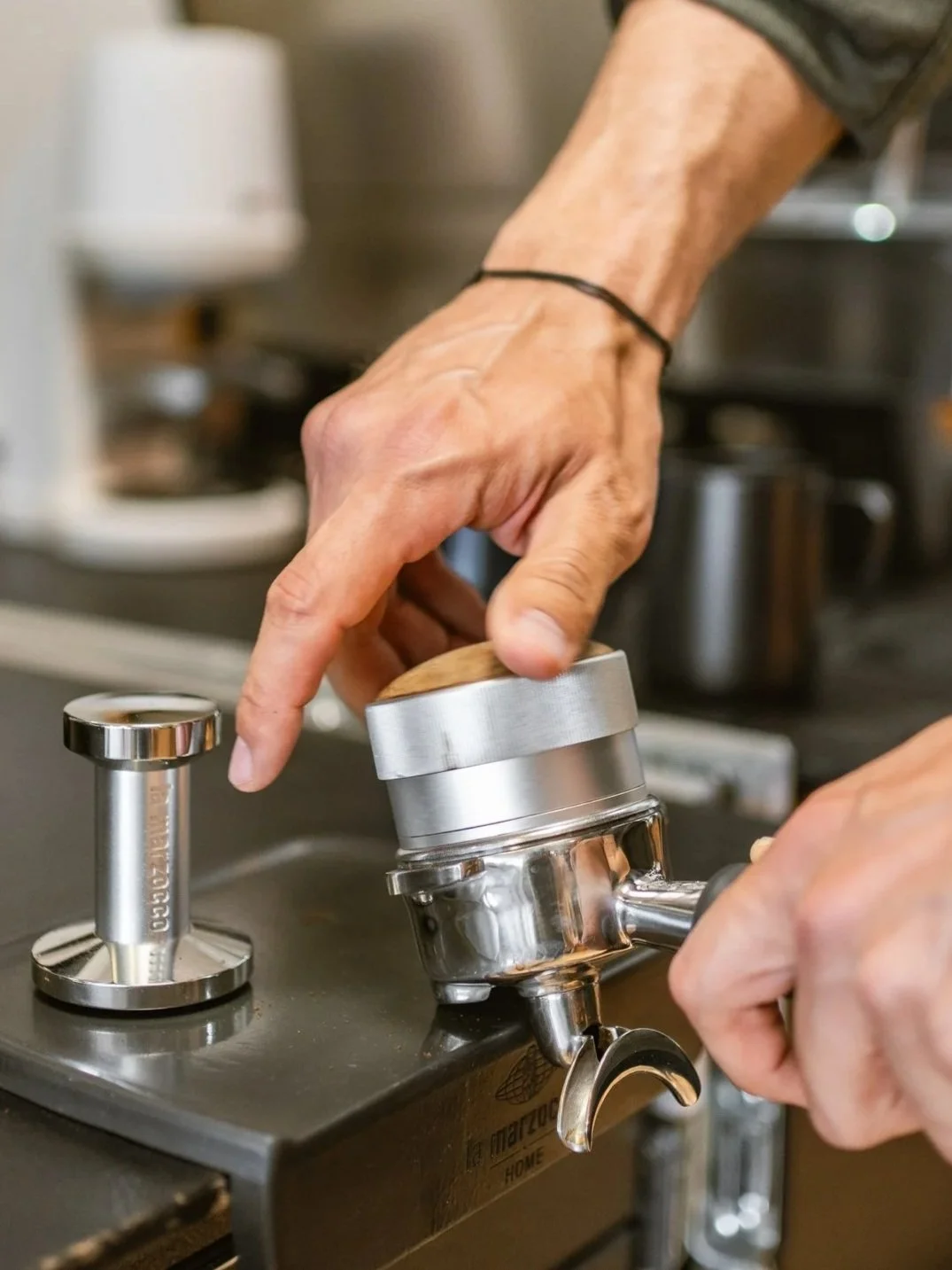 Ein Barista bereitet mit einer Siebträgermaschine einen Espresso zu.