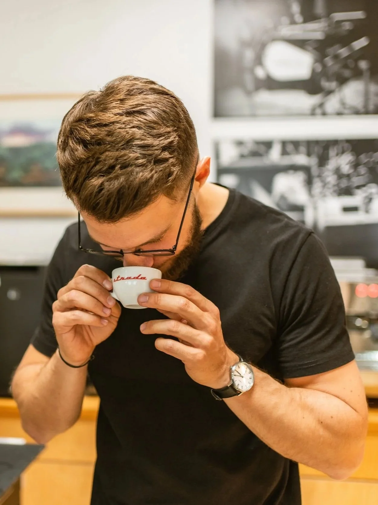 Ein Mann trinkt Kaffee aus einer kleinen weißen Tasse.