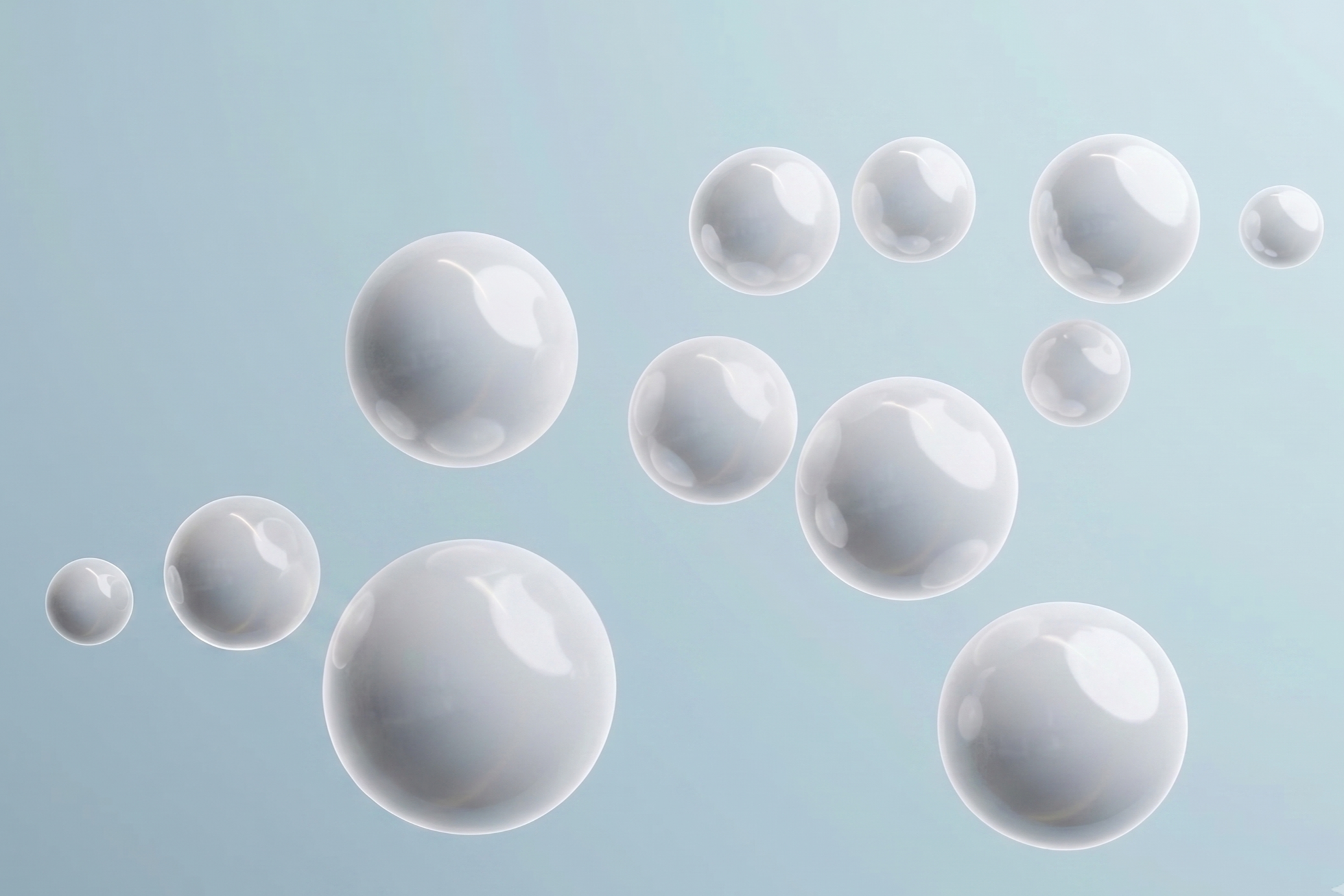 Floating white spheres of various sizes against a light blue background.