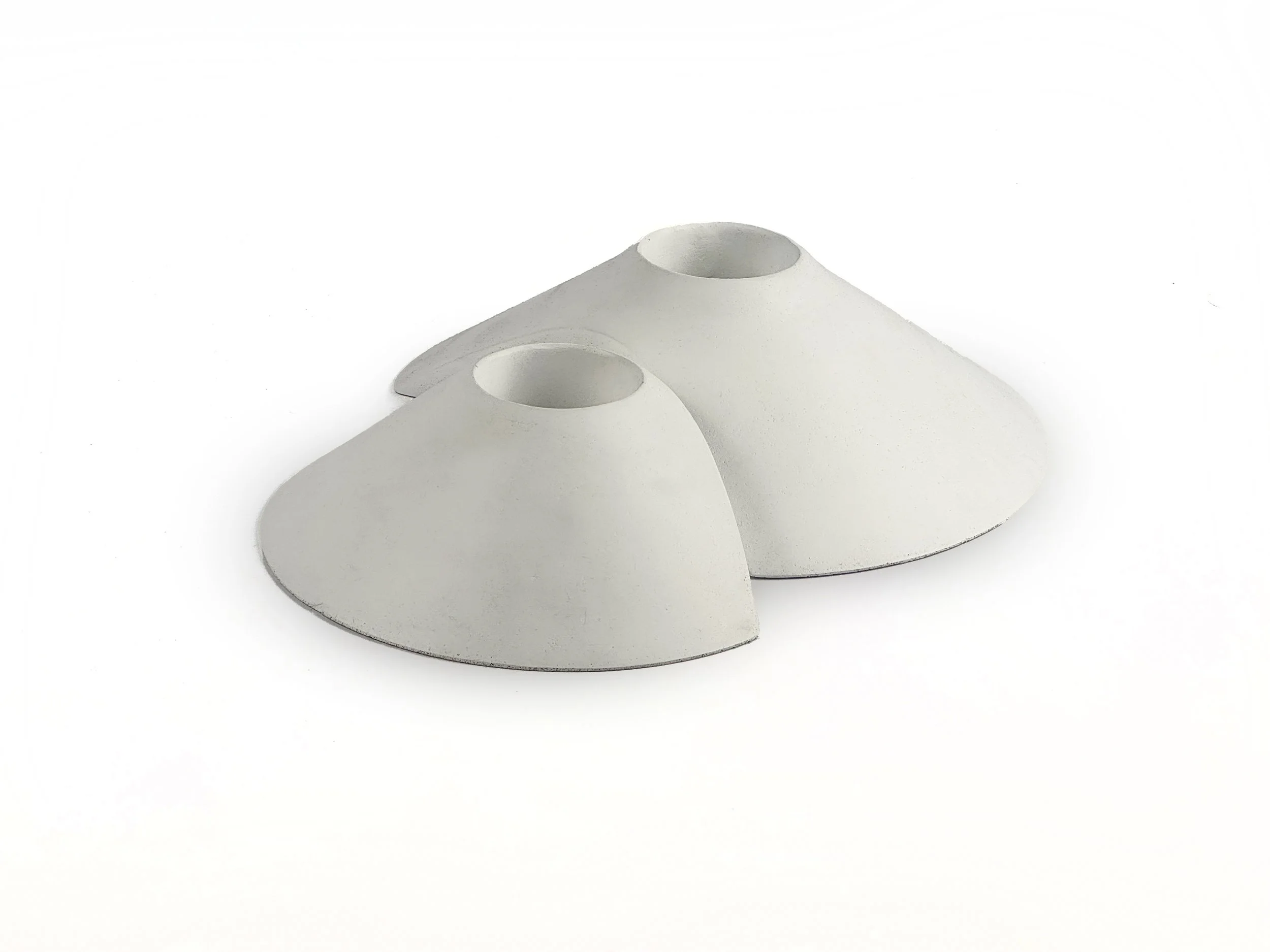 Two white, pyramid-shaped objects with circular holes on a white background.