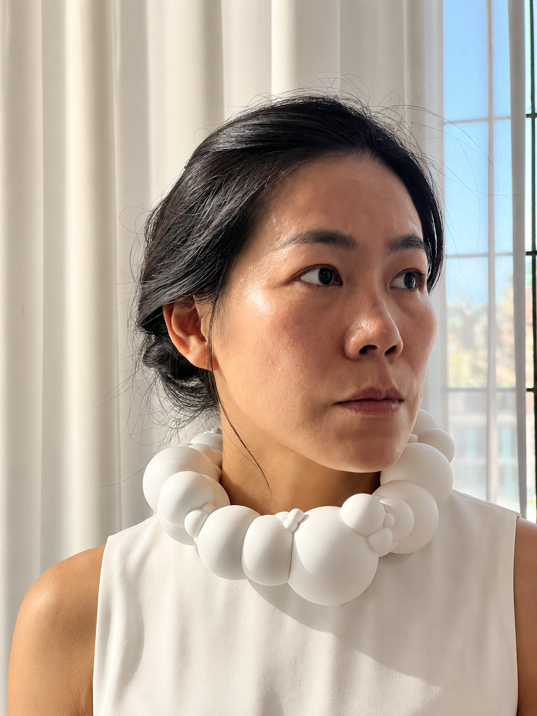 Contemplative Portrait with Sculptural Bubble Necklace.png