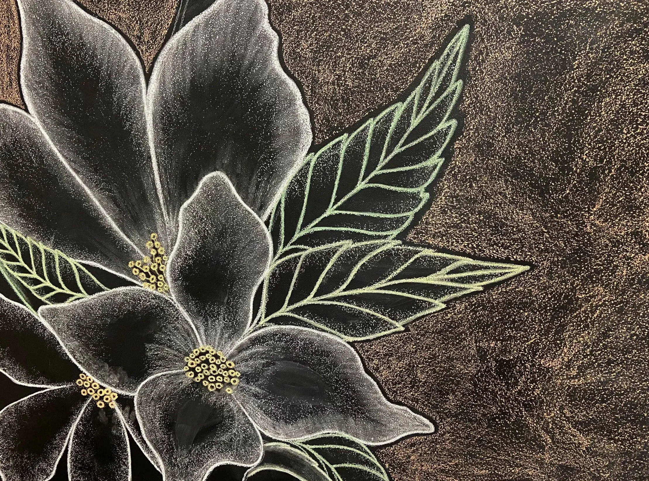 Close-up of a floral chalk drawing on a black background, depicting a large white flower with yellow center and green-lined leaves.