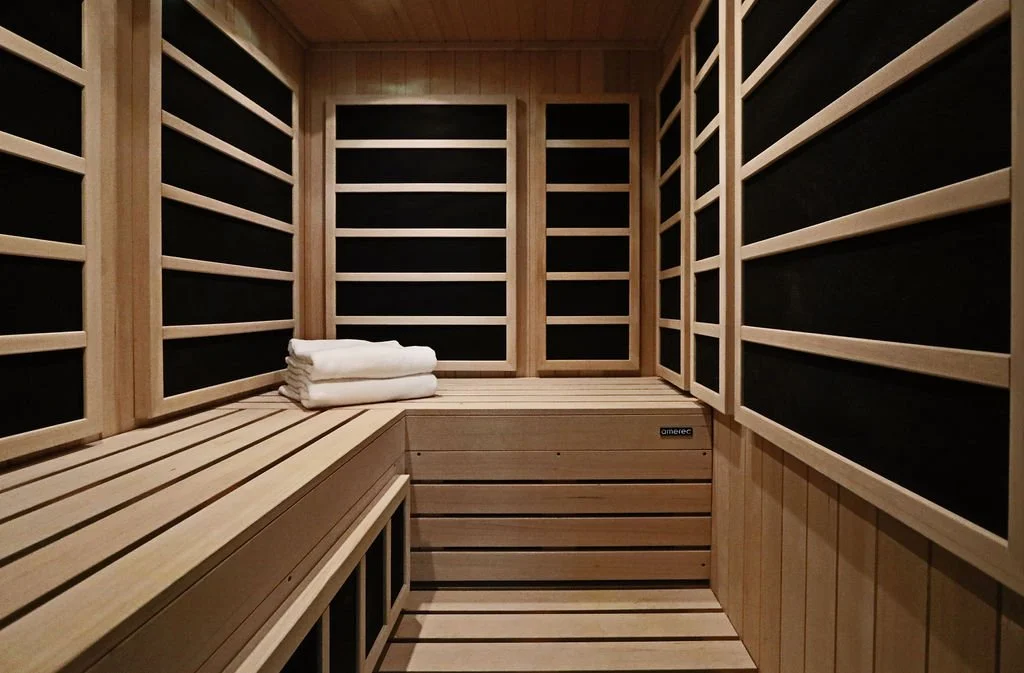 Custom two-person infrared sauna with wood bench seating and black panel walls