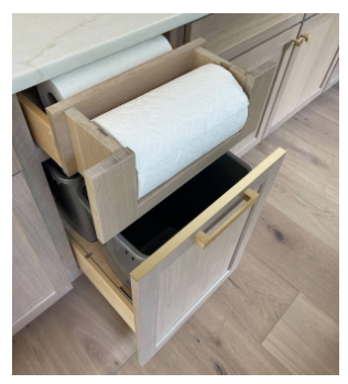 Hidden paper towel pull-out cabinet with integrated recycling storage designed to reduce countertop clutter and improve kitchen organization.