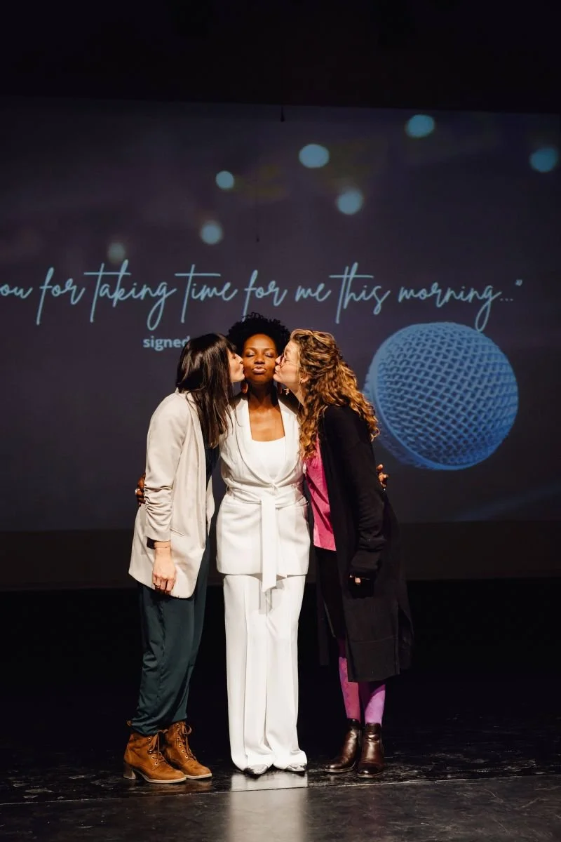Drei Frauen stehen eng beieinander auf einer Bühne. Das Bild steht für Verbundenheit, weibliche Solidarität und die emotionale Kraft von Musik bei RISE.