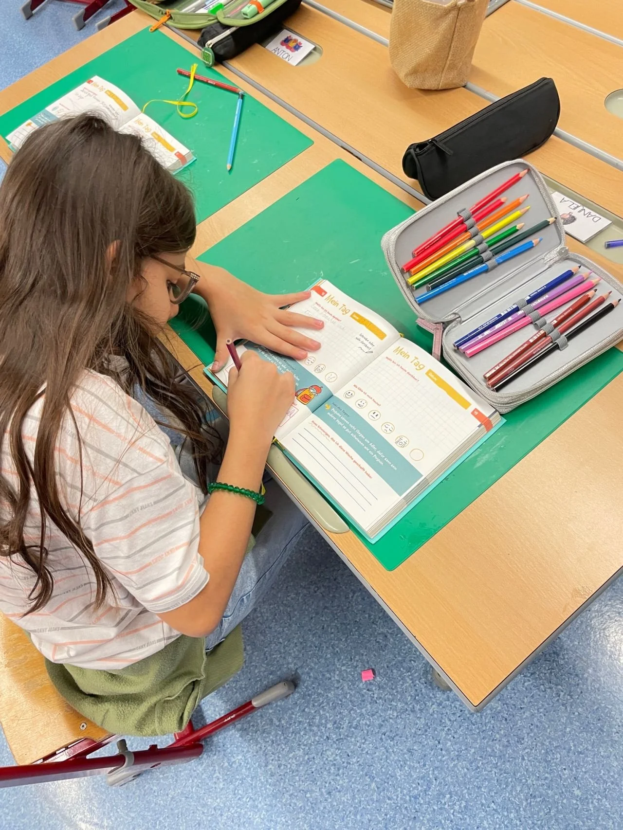 Kind zeichnet konzentriert in sein Journal während einer Achtsamkeitsübung im Unterricht.