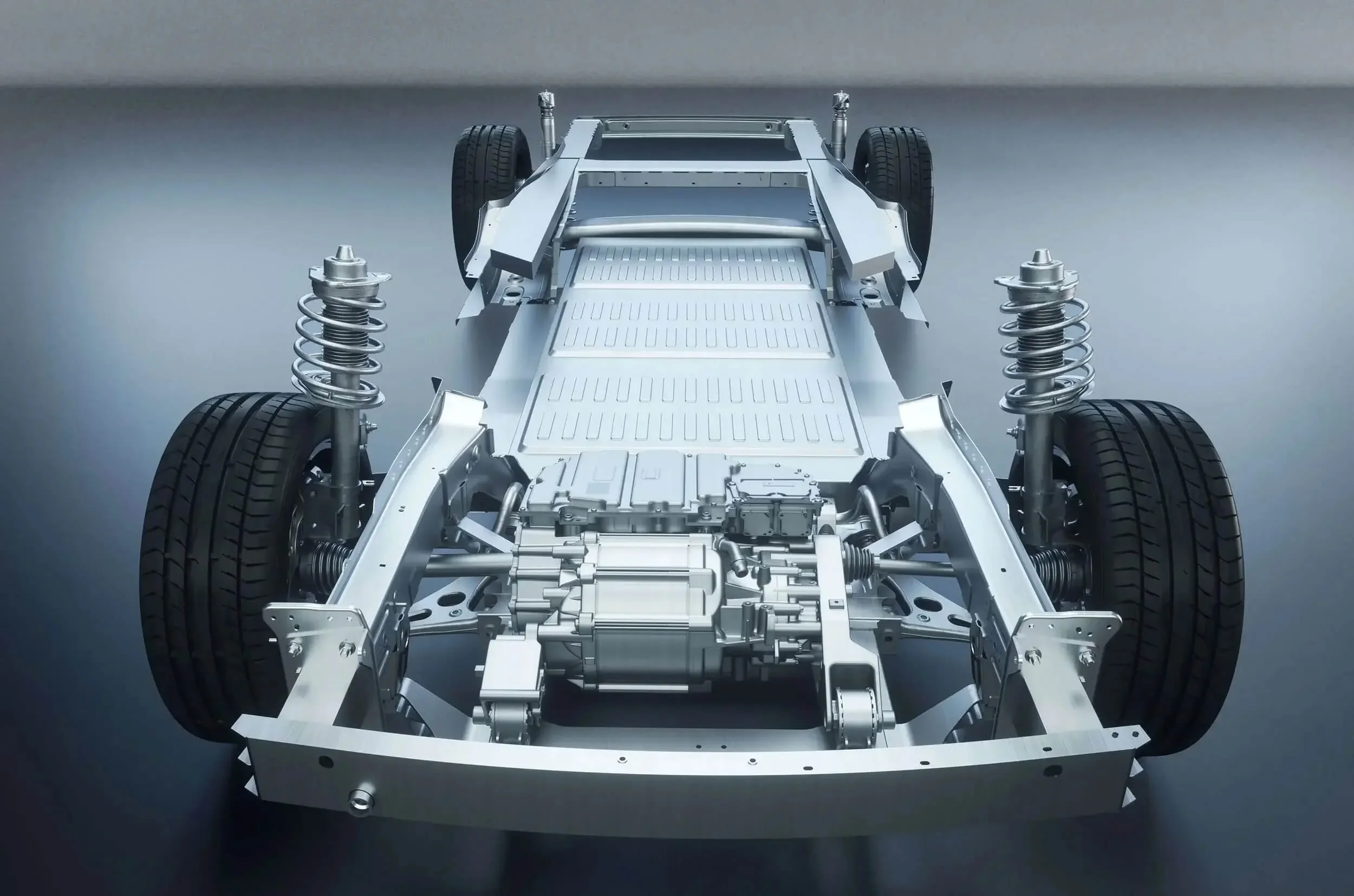 Chasis de coche eléctrico con componentes metálicos, suspensión, ruedas y motor visible.