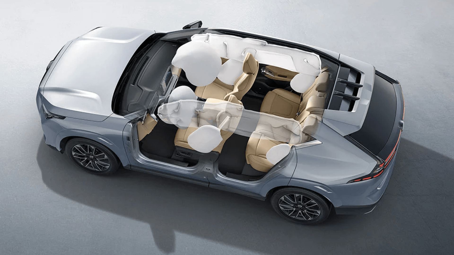 Vista interior de un auto eléctrico marca GAC con techo abierto y asientos de color beige, mostrando componentes del sistema de airbags y estructura de seguridad.