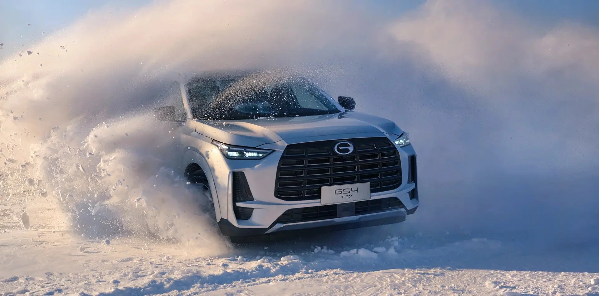 Coche SUV blanco de marca GAC avanzando sobre nieve, creando una explosión de nieve a su alrededor.