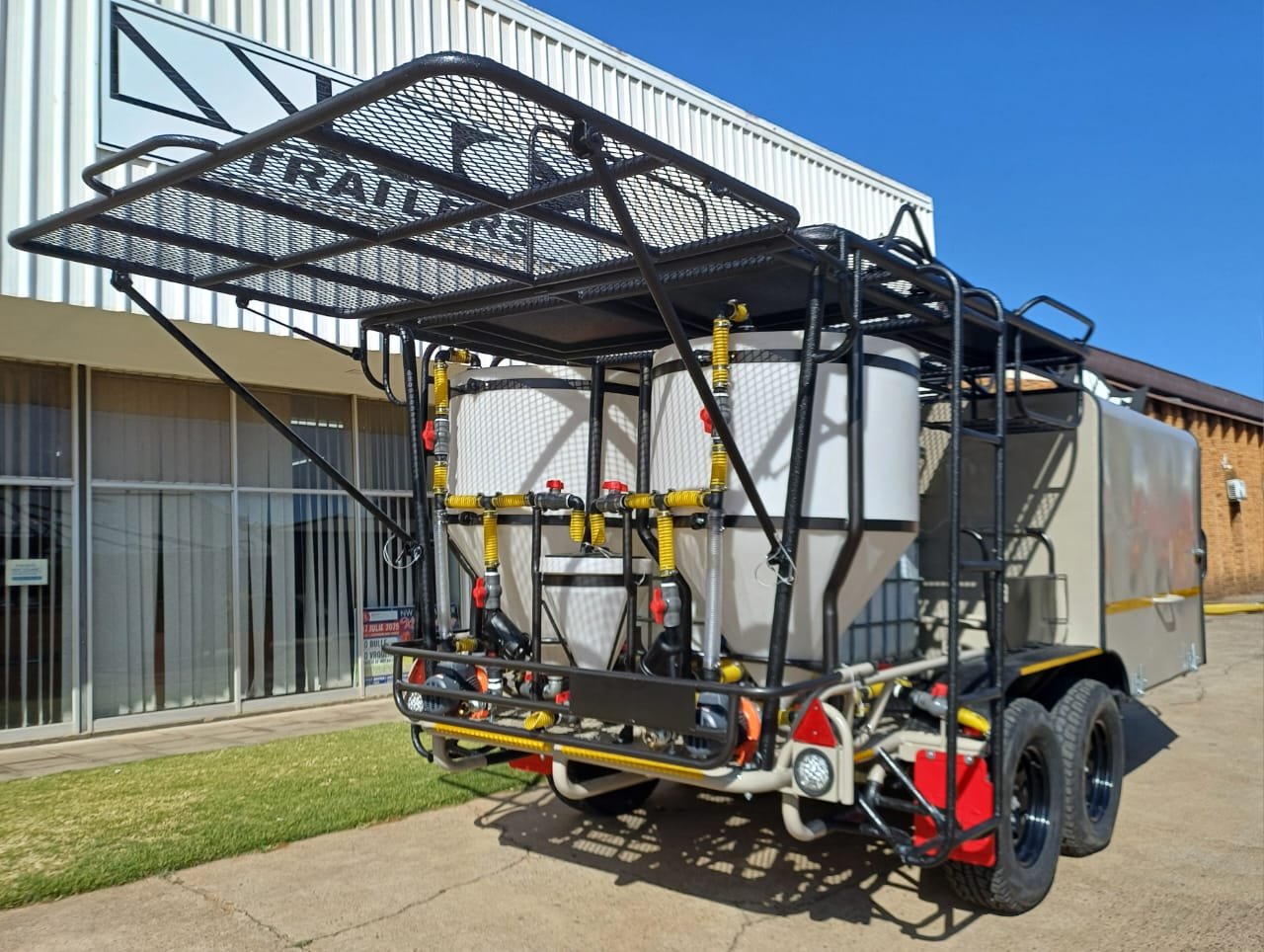 A mobile firefighting water tank and pump system with an elevated platform and hose connections, mounted on a trailer.