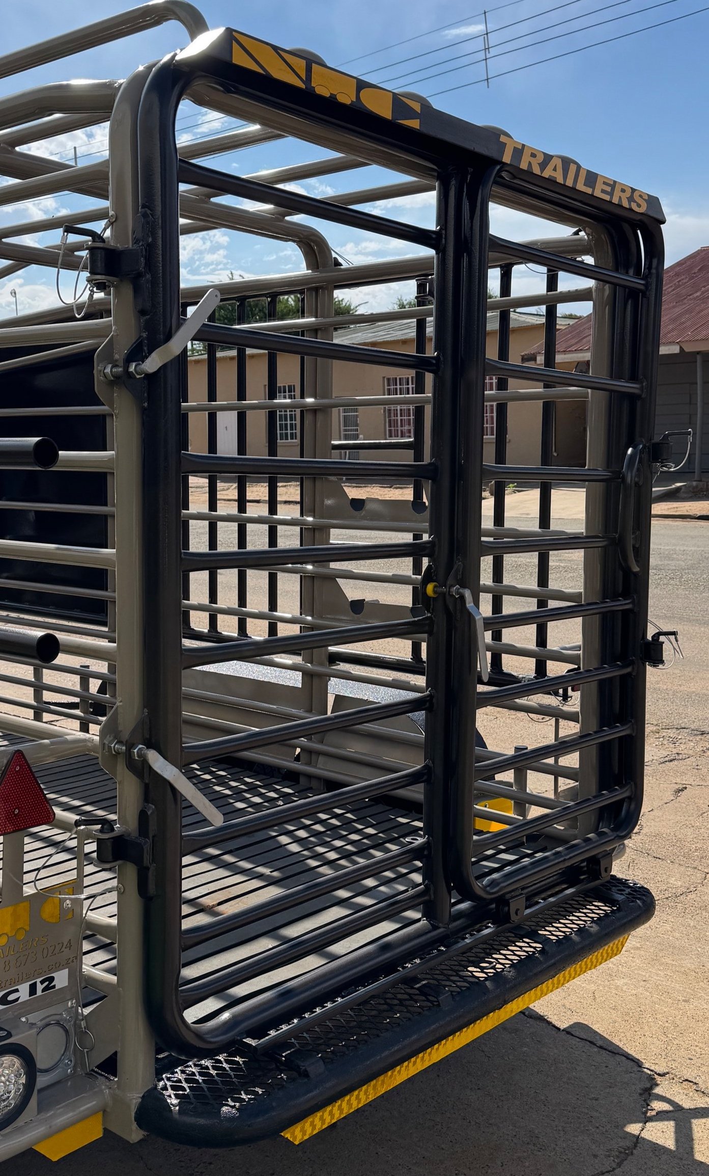 Livestock trailer gate with metal bars, part of a transport vehicle.