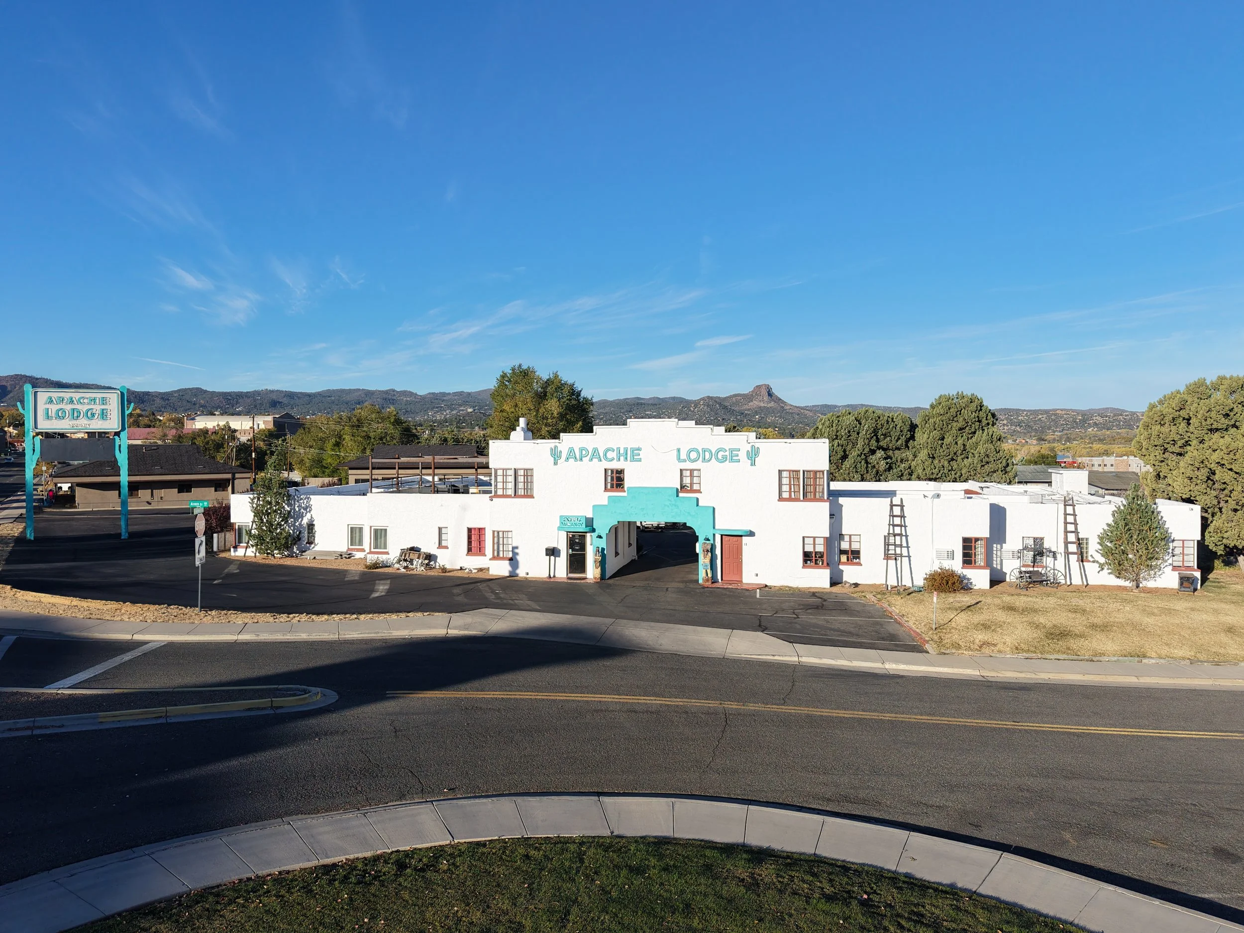 Apache Lodge building and sign with mountainous background on a sunny day