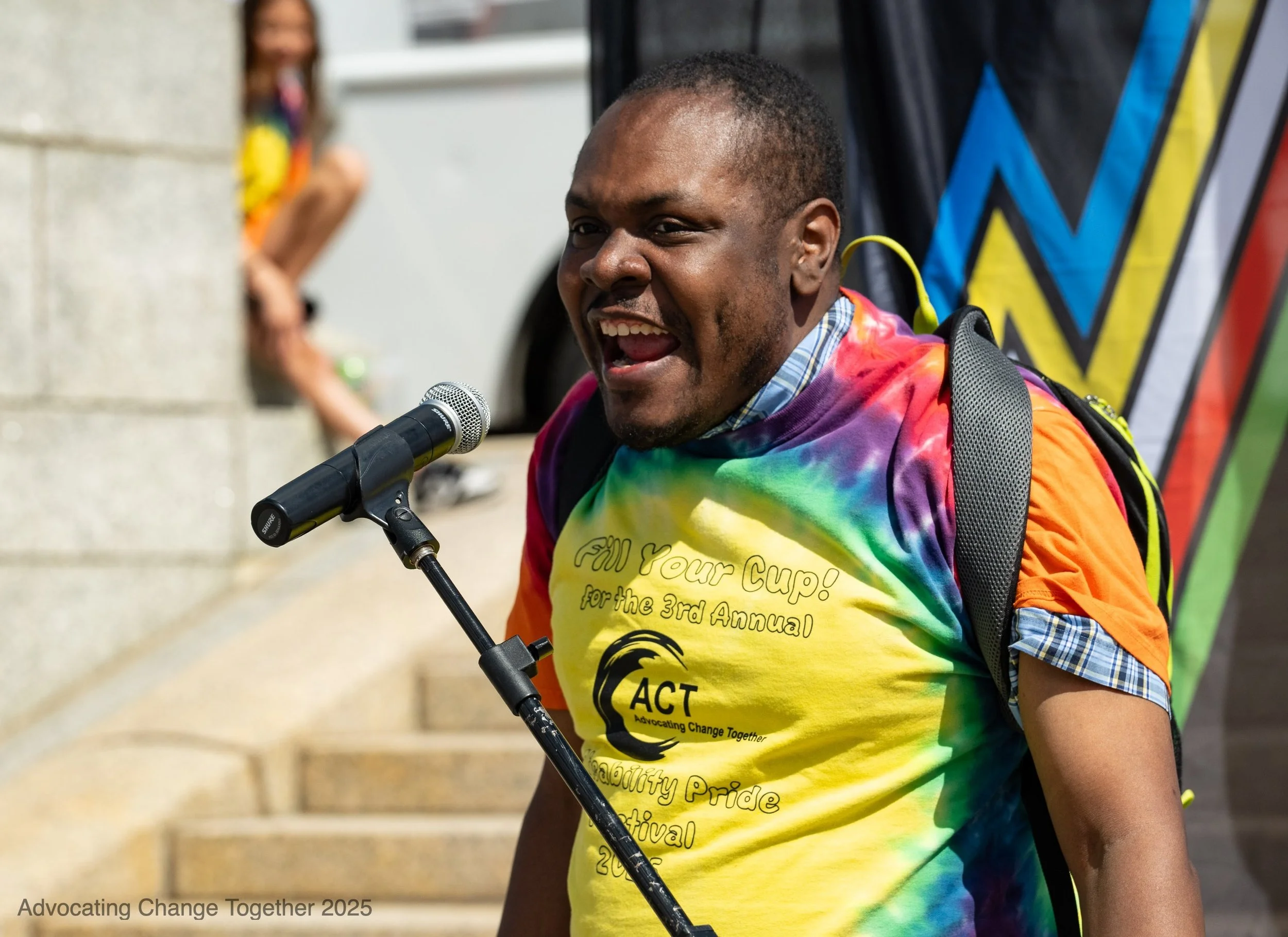 Person sharing their experiences via an open mic at the 3rd annual disability pride festival.