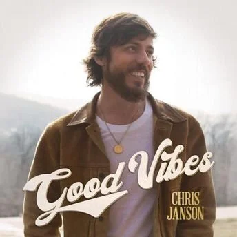 Album cover of good vibes by Chris Janson. He is smiling on the cover wearing a brown jacket.