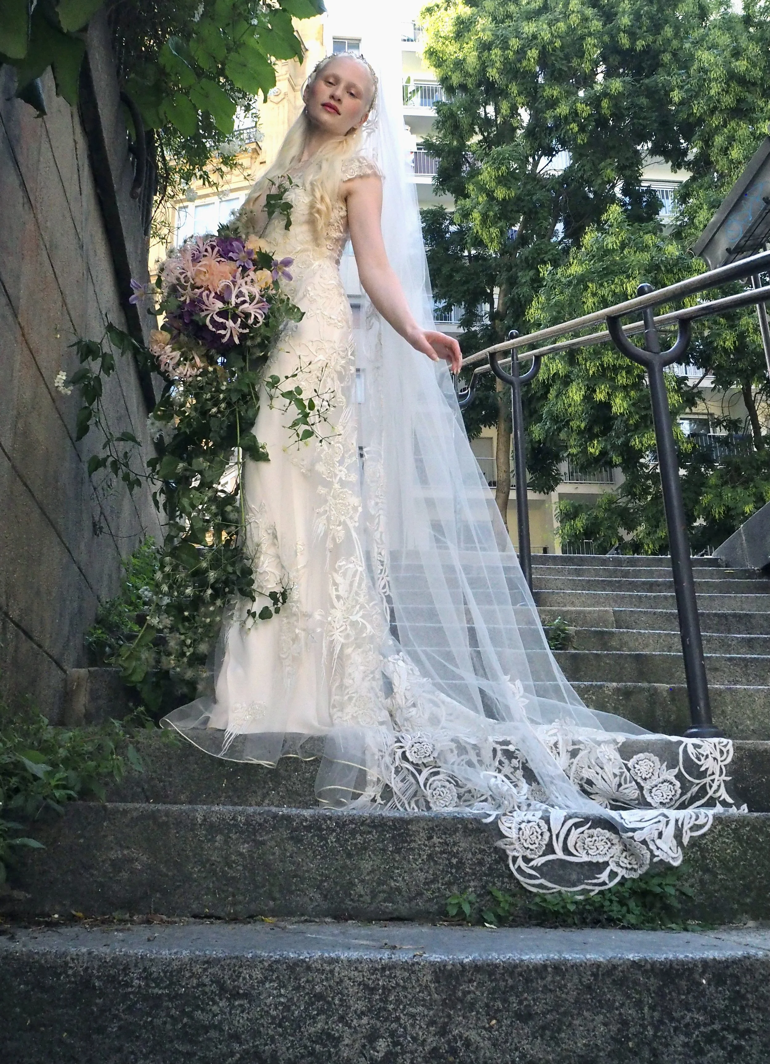 The Delilah Gown in Arte Nouveau embroidered tulle from Italy over Italian silk, deep lunging V neckline with embroidered overlay and delicate Swarovski beading, cap sleeves and chapel train. Matching Embroidered veil. Pale gold and Ivory embroidered