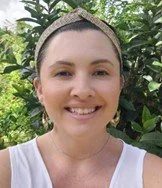 Amber De Vogt smiling in front of greenery