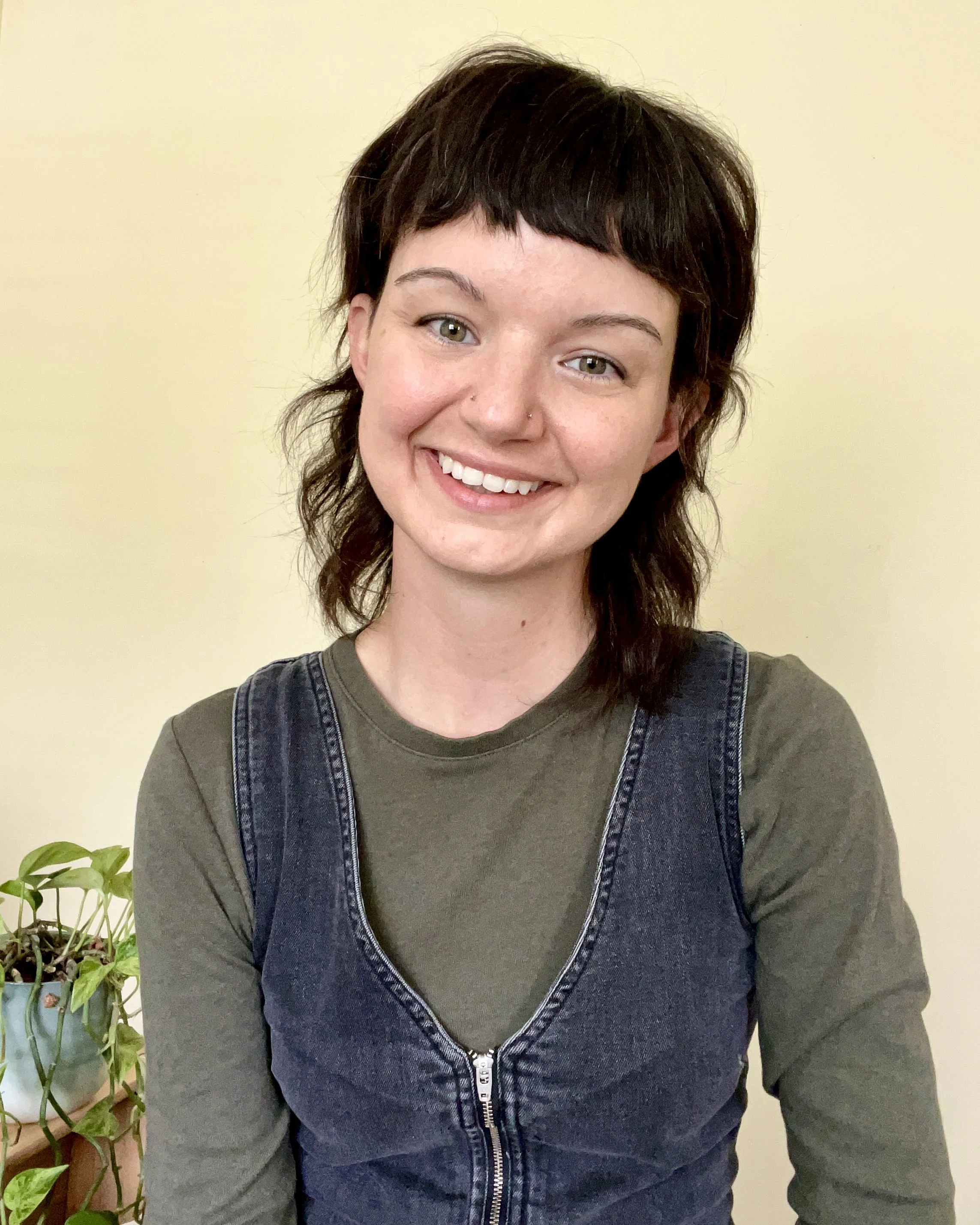 Image of a woman with short brown hair and bangs smiling, looking at the camera