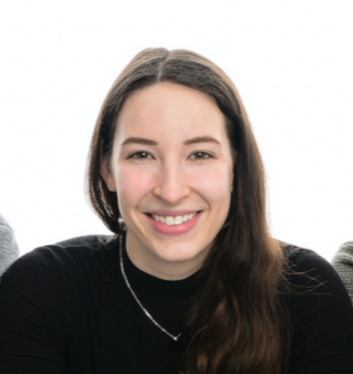 Woman with long brown hair smiling and looking at the camera. 