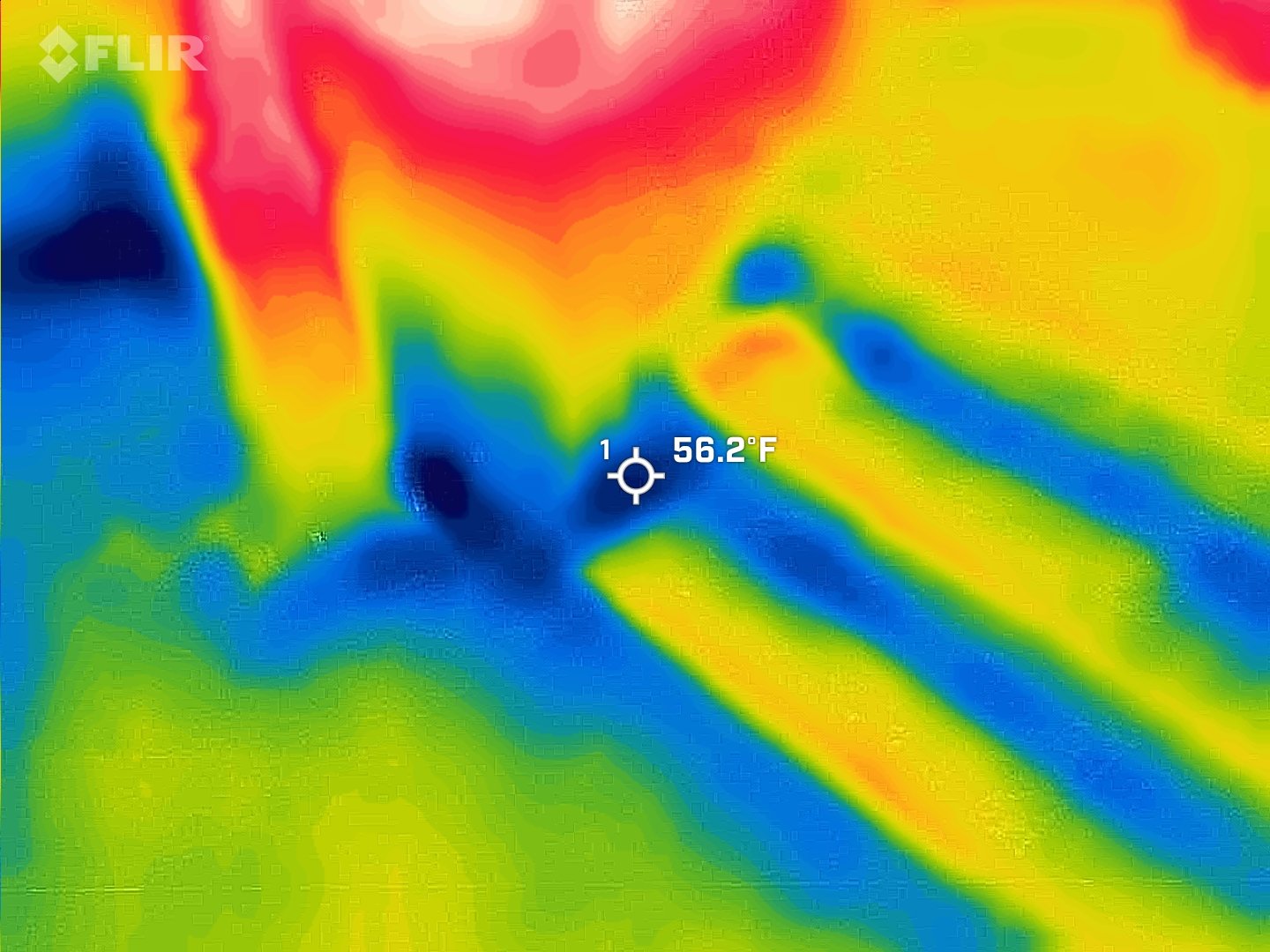 Thermal image showing hand holding a smartphone with a temperature reading of 56.2°F and color spectrum from blue to red indicating temperature variations.