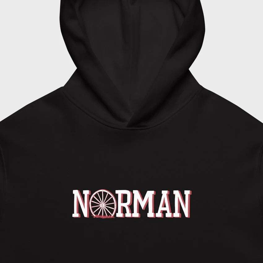Closeup of the Norman Oklahoma heavyweight hoodie in black with hand-drawn Norman wagon wheel graphic on chest.