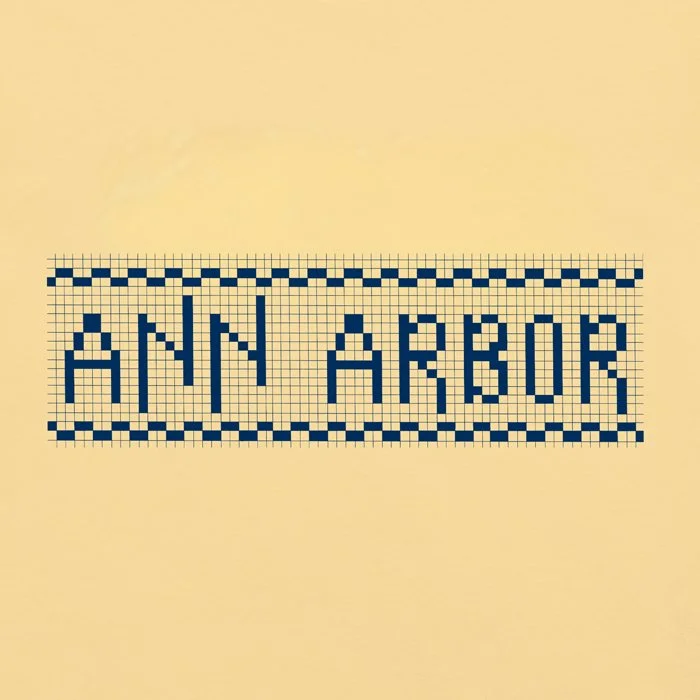 Closeup of the Ann Arbor "Zingerman's" design on a garment dyed t-shirt in yellow.