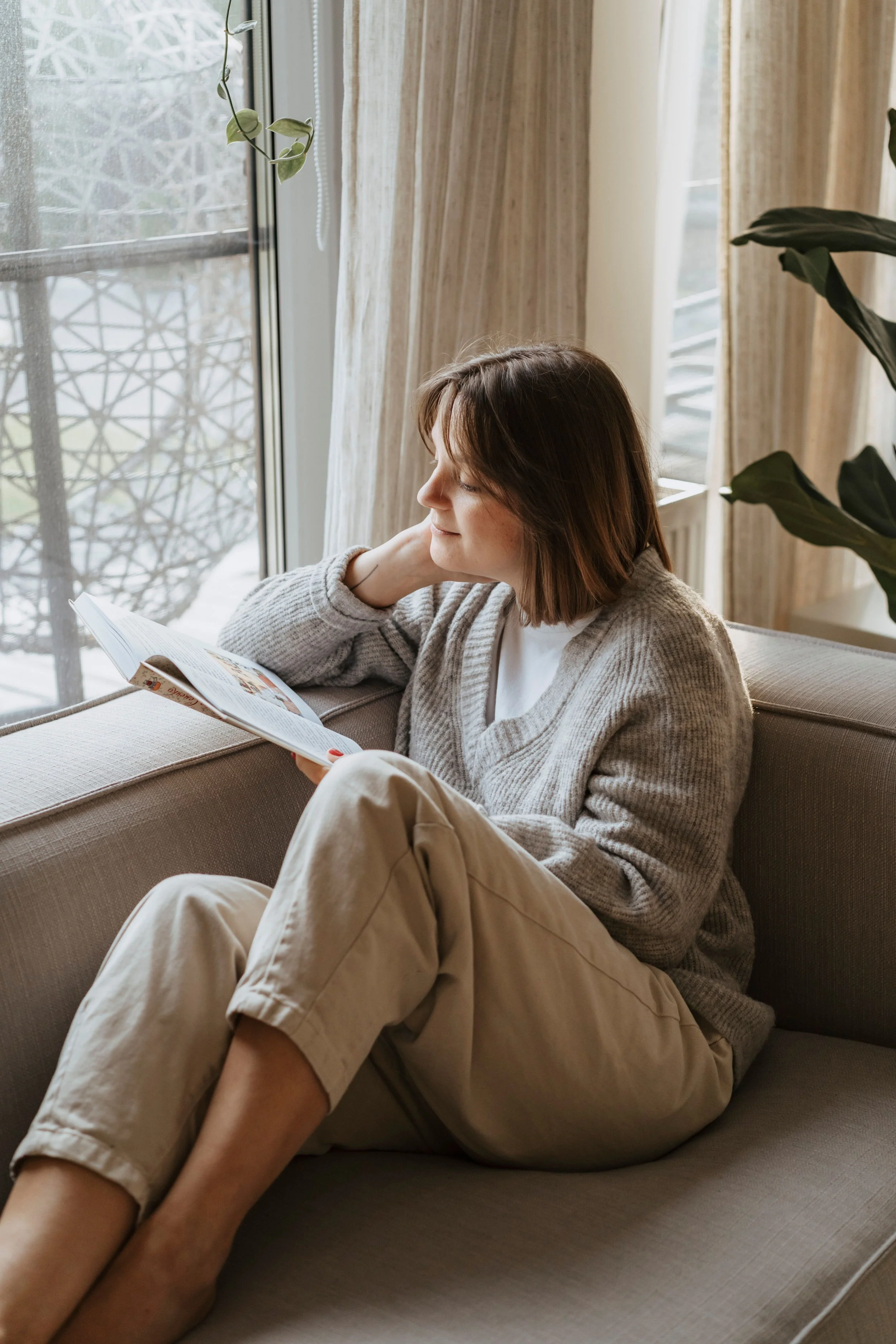 Woman relaxing by a window while reading