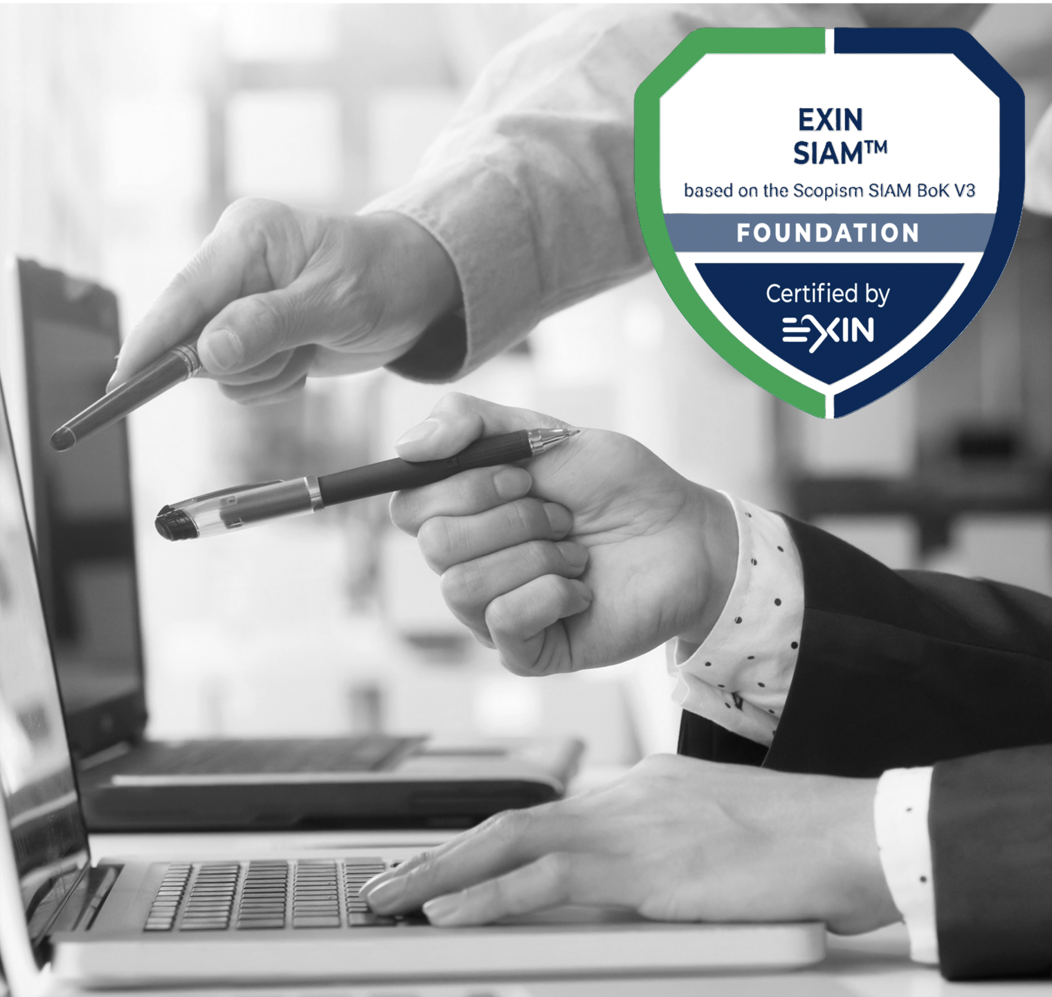 Black and white photo of two people working on a laptop, one person pointing at the screen with a pen, the other typing on the keyboard with a pen in hand, with a logo in the top right corner indicating certification by EXIN for the Exin SIAM Foundation.