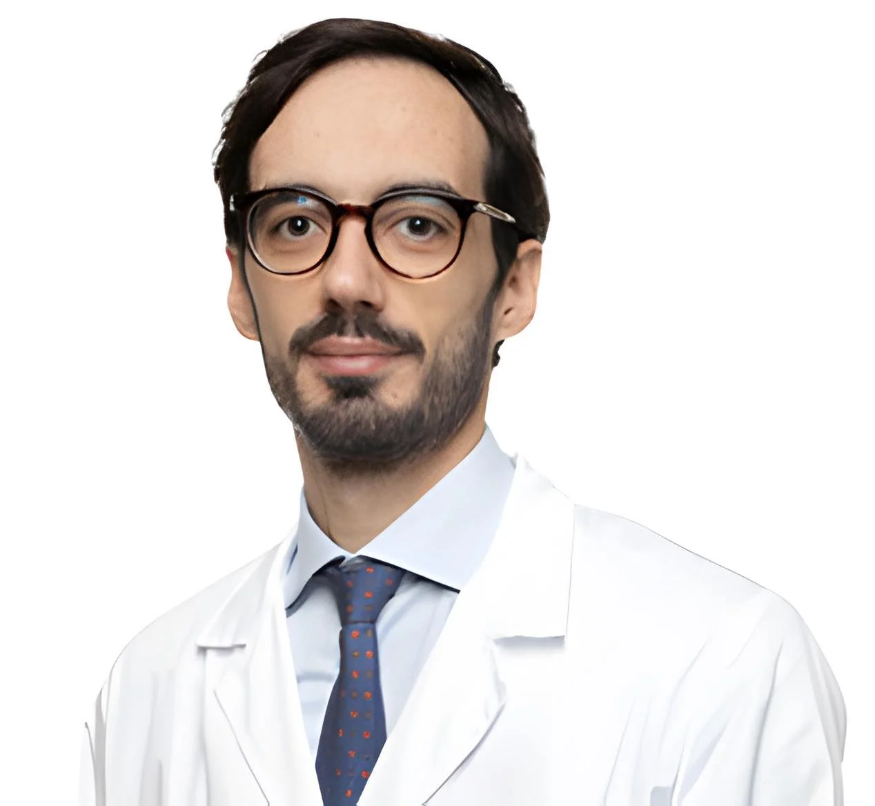 Medico uomo con occhiali, barba, baffi, capelli castani, in camice bianco e cravatta con pois colorati, contro sfondo bianco.