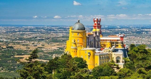 Stunning view of the vibrant Pena Palace perched atop a hillside, renowned for its unique and colorful architecture.